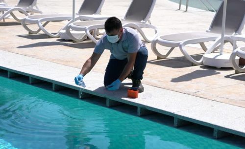Pool testing kit being used in a swimming pool