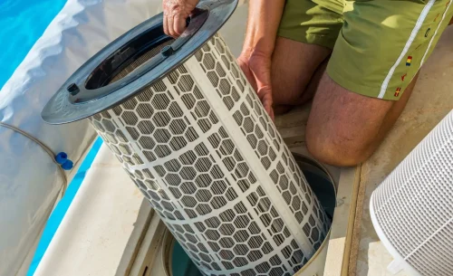 man-replacing-pool-filter-beside-the-pool